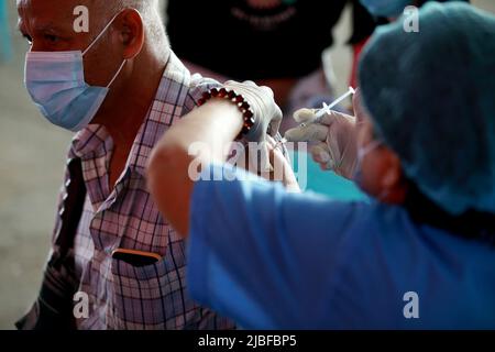 Yangon, Myanmar. 6th juin 2022. Un homme reçoit une dose du vaccin COVID-19 à Yangon, au Myanmar, au 6 juin 2022. Le Myanmar a entièrement vacciné plus de 26,8 millions de personnes contre le COVID-19 samedi, selon le ministère de la Santé dimanche. Credit: U Aung/Xinhua/Alamy Live News Banque D'Images