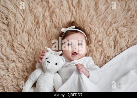 Bébé fille avec ours jouet. Carte postale Fête des mères et Pâques. Journée de la protection des enfants. Journée mondiale du bonheur. Enfant souriant Banque D'Images