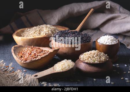 Différents types de riz dans des bols en bois Banque D'Images