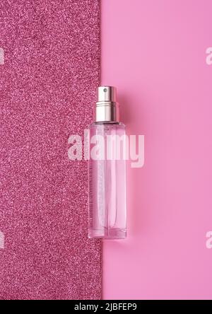 Composition Flat Lay avec bouteille de parfum élégante sur fond rose vif et étincelant. Concept cosmétique. Maquette pour votre conception avec espace de copie. Banque D'Images