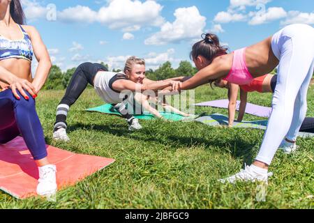 Les femmes de groupe s'échauffent avant de s'entraîner à s'étirer, à faire de l'exercice en plein Banque D'Images