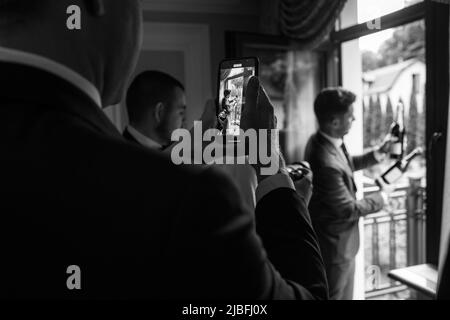 Le client prend une photo du marié avec des bouteilles de champagne. Banque D'Images