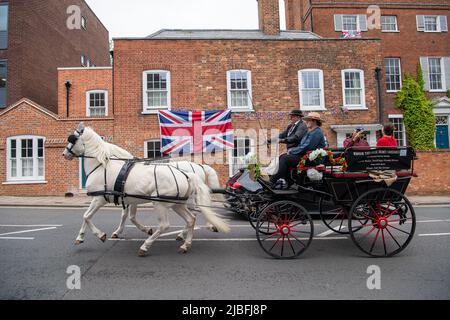 Windsor, Berkshire, Royaume-Uni. 5th juin 2022. Un cheval et une calèche passent un grand drapeau de l'Union Jack vole à l'extérieur d'une maison à Sheet Street, Windsor, alors que les Windsorians célèbrent le Jubilé de platine. Crédit : Maureen McLean/Alay Live News Banque D'Images