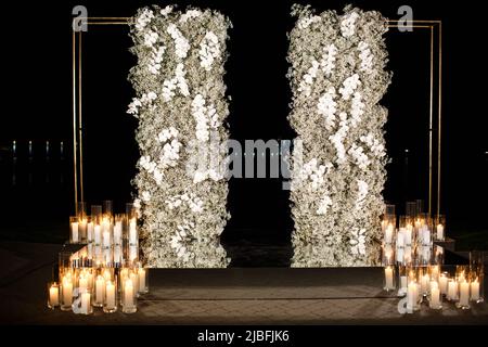 Arc pour une cérémonie de mariage en plein air avec bougies. Banque D'Images