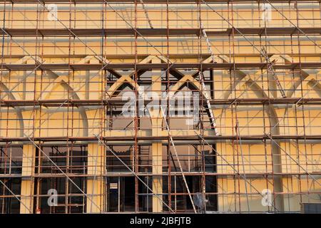 Un bâtiment en rénovation recouvert d'échafaudages métalliques, montrant des travaux de construction détaillés et des efforts de restauration sur la façade architecturale. Banque D'Images
