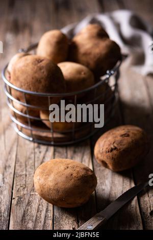 Grand angle de pommes de terre crues placées sur une table en bois dans la cuisine Banque D'Images