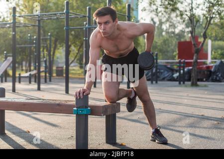 Un homme musclé lève la haltère. Exercice arrière. Rangée d'haltères à bras unique Banque D'Images