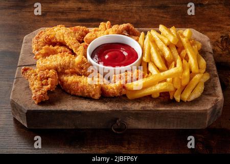 Quartiers de poulet battus, nuggets croustillants, avec une sauce barbecue sur une table en bois, restauration rapide américaine Banque D'Images