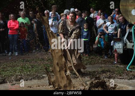 Hergisdorf, Allemagne. 06th juin 2022. Les hommes s'assoient dans un trou de boue au Dirty Pig Festival de 2022 à Hergisdorf sur le site du festival sur le Wildbahn. À la fête de la forêt, l'hiver est symboliquement chassé par le festival Dirty Pig. Pour cela, les hommes sautent dans un trou de boue. Credit: Matthias Bein/dpa/Alay Live News Banque D'Images