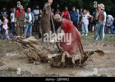 Hergisdorf, Allemagne. 06th juin 2022. Les hommes s'assoient dans un trou de boue au Dirty Pig Festival de 2022 à Hergisdorf sur le site du festival sur le Wildbahn. À la fête de la forêt, l'hiver est symboliquement chassé par le festival Dirty Pig. Pour cela, les hommes sautent dans un trou de boue. Credit: Matthias Bein/dpa/Alay Live News Banque D'Images