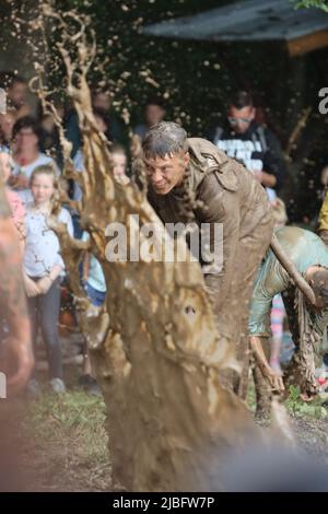 Hergisdorf, Allemagne. 06th juin 2022. Les hommes s'assoient dans un trou de boue au Dirty Pig Festival de 2022 à Hergisdorf sur le site du festival sur le Wildbahn. À la fête de la forêt, l'hiver est symboliquement chassé par le festival Dirty Pig. Pour cela, les hommes sautent dans un trou de boue. Credit: Matthias Bein/dpa/Alay Live News Banque D'Images