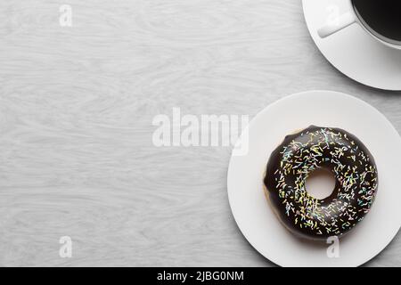 Dougout et café sur une assiette, fond en bois blanc, rendu 3D. Espace de copie, fond de nourriture, délicieux beignet avec glaçage au chocolat Banque D'Images