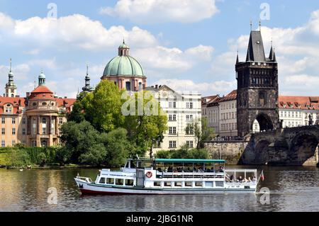 Architecture emblématique près de la rivière Vltava, avec bateau touristique, près du pont Charles à Prague Banque D'Images