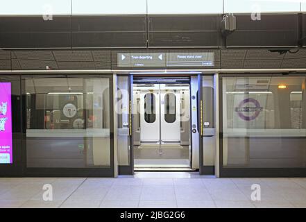 Londres, Royaume-Uni. Un train sur la nouvelle ligne Elizabeth (Crossrail) attend à la gare de Whitechapel. Portes de l'écran de train et de sécurité ouvertes, panneau d'information ci-dessus. Banque D'Images