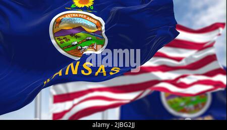 Le drapeau de l'État du Kansas agité avec le drapeau national des États-Unis d'Amérique. En arrière-plan, il y a un ciel clair. Le Kansas est un État i. Banque D'Images