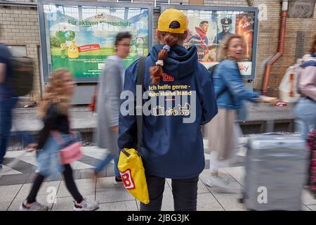 Hambourg, Allemagne. 06th juin 2022. Un employé de Deutsche Bahn est debout sur la plate-forme 13 et porte une veste avec l'inscription « Je suis heureux de vous aider - votre main forte » (effet d'essuyage dû à une longue exposition). Les soi-disant chauffeurs de passagers de l'équipe de service aident les voyageurs à trouver le bon train et à charger les bagages, les voitures d'enfants et les vélos. Credit: Georg Wendt/dpa/Alay Live News Banque D'Images