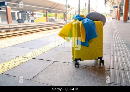 valise jaune avec drapeau ukrainien à la gare d'immigration réfugié Banque D'Images