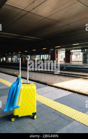 valise jaune avec drapeau ukrainien à la gare d'immigration réfugié Banque D'Images