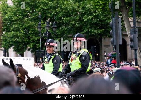 Gros plan de deux officiers de police féminins montés souriant devant la foule, à la fin du survol pour célébrer le Trooping de la couleur : la parade d'anniversaire de la Reine, dans le cadre de ses célébrations du Jubilé de platine 2022 Banque D'Images