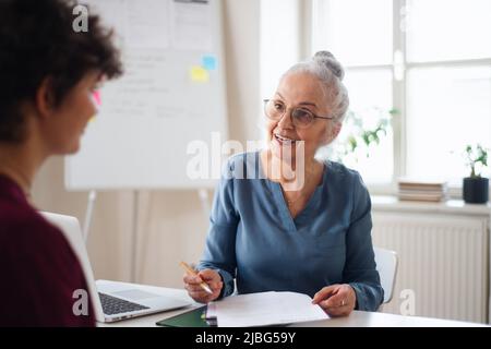 Femme recruteuse senior souriant pendant l'entrevue d'emploi. Banque D'Images