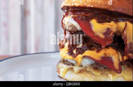 Un grand hamburger, hamburger ou cheeseburger fumé sur une assiette. Vue rapprochée avec espace de copie. Banque D'Images