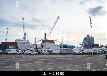 Voitures, caravanes et camping-cars faisant la queue pour un ferry au port international de Portsmouth montrant les bâtiments, signez au terminal de ferry international et tra Banque D'Images