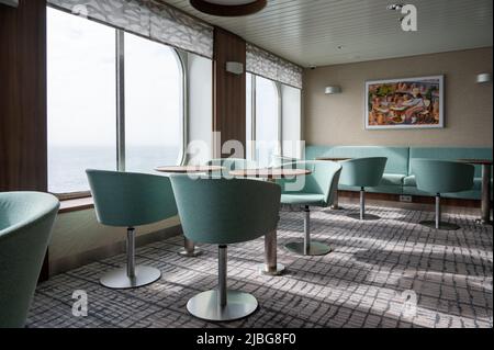 Un salon sur le ferry Brittany Ferries avec des tables et des chaises pour les passagers. Banque D'Images