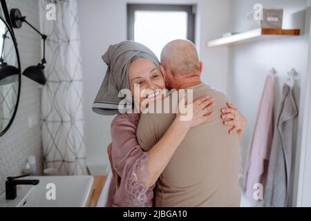 Couple senior amoureux dans la salle de bains embrassant, concept de routine du matin. Banque D'Images