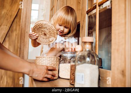 Petite fille aide maman dans la cuisine avec des tâches ménagères Banque D'Images