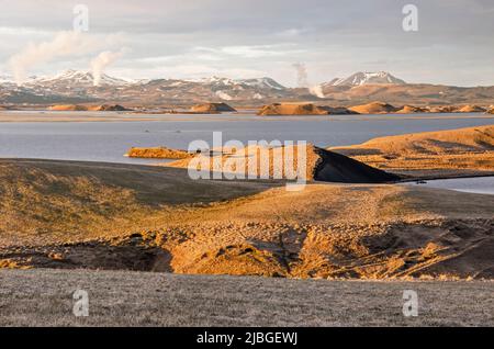 Skútustaðir, Islande, 27 avril 2022: Les derniers rayons du soleil illuminent le paysage étrange autour du lac Myvatn, d'où s'échappent les panaches de vapeur chaude Banque D'Images