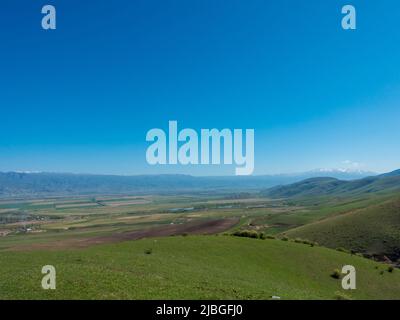 Pistes vertes et ciel bleu. Kirghizistan Banque D'Images