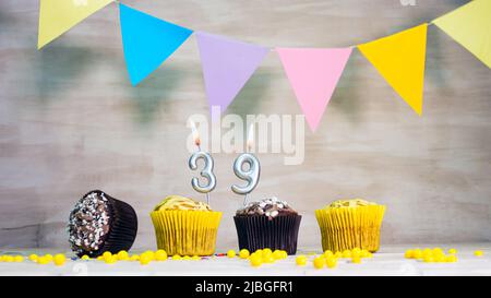 Arrière-plan anniversaire avec numéro. Belle carte d'anniversaire avec guirlandes colorées, un muffin avec une bougie imitateur. Banque D'Images