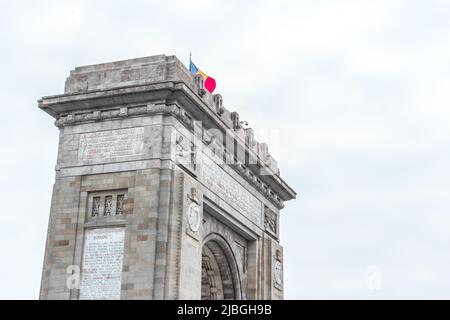 Arcul de TRIUMF (Arche de Triumphal) avec drapeau en hiver, Bucarest, Roumanie. Il est situé dans la partie nord de Bucarest, sur la route Kiseleff Banque D'Images