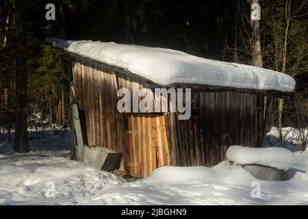 Neige sur le toit de la grange en bois. Ferme. Hiver dans le village. Ancienne maison en planches. Banque D'Images