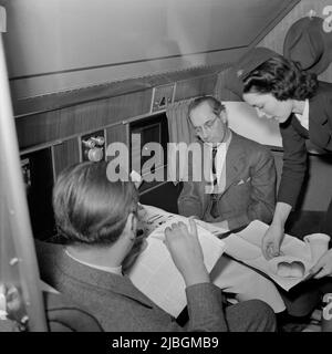 Photo vintage vers 1941 d'un agent de bord qui cherche à servir de la nourriture et des boissons aux passagers voyageant dans un avion de ligne Douglas DC3 en vol de Washington DC à Los Angeles Banque D'Images