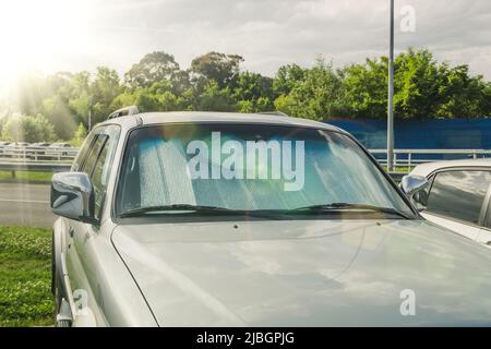 L'écran de protection du pare-brise reflète la chaleur et les rayons du soleil réchauffent l'intérieur de la voiture Banque D'Images