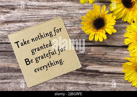 Citation motivationnelle sur papier brun déchiré - ne prenez rien pour acquis, soyez reconnaissant pour tout. Banque D'Images