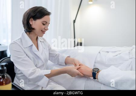 Un cosmétologue travaillant avec le client dans un salon de spa Banque D'Images