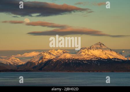 Lever de lune et coucher de soleil sur les montagnes Kenai et la baie de Kachemak dans le centre-sud de l'Alaska. Banque D'Images