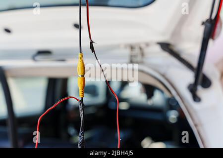 Branchement avec fil de cuivre enveloppé dans du ruban adhésif pour installer la caméra de recul sur la voiture Banque D'Images