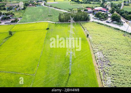 Vue aérienne du pôle haute tension, tour de transmission, pylône d'électricité, transmission d'énergie électrique situé sur le champ de riz dans la campagne à l'arrière Banque D'Images