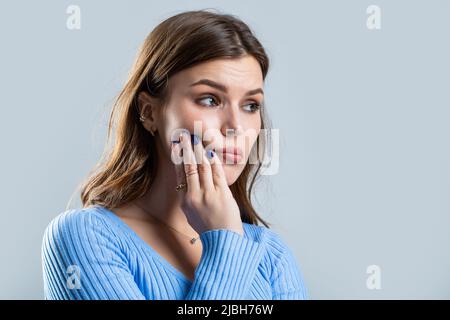 Mal de dents, femme atteinte d'une infection de la dent. Femme souffrant de maux de dents sur fond gris. Jeune femme souffrant de mal de dents. Fille souffrant Banque D'Images