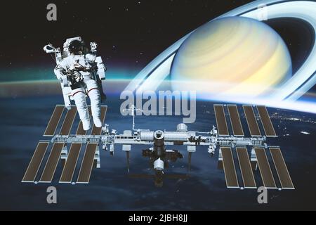 L'astronaute effectue une sortie spatiale au-dessus de la station spatiale internationale, tandis que la fantaisie en arrière-plan voit la planète saturne. Éléments de cette image Banque D'Images