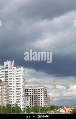 Grue de tour sur la construction d'un bâtiment avec un cadre de béton armé. Le soleil se pare d'un ciel bleu. Banque D'Images