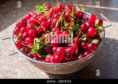 Cerises dans un tamis en acier. Vue de dessus, texture Banque D'Images