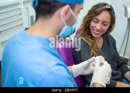 Femme souriant à l'explication du dentiste Banque D'Images