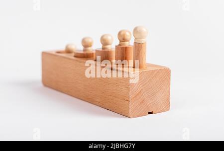 Bloc avec cylindres à bouton Montessori mal placés. Impossible de trouver le trou approprié pour la pièce. Puzzle pour enfants pour le développement de la coordination et de la concentration de la main d'oeil. Photo de haute qualité Banque D'Images