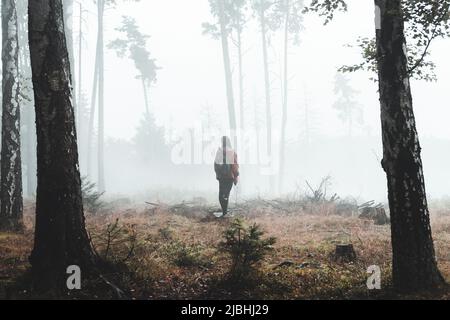 Une femme se tient dans une forêt humide et brumeuse. République tchèque, Suisse de Bohême Banque D'Images