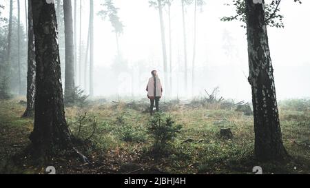 Une femme se tient dans une forêt humide et brumeuse. République tchèque, Suisse de Bohême Banque D'Images