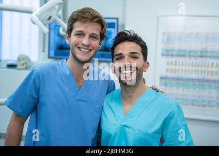 Deux jeunes dentistes souriant avec uniforme dans la clinique dentaire Banque D'Images